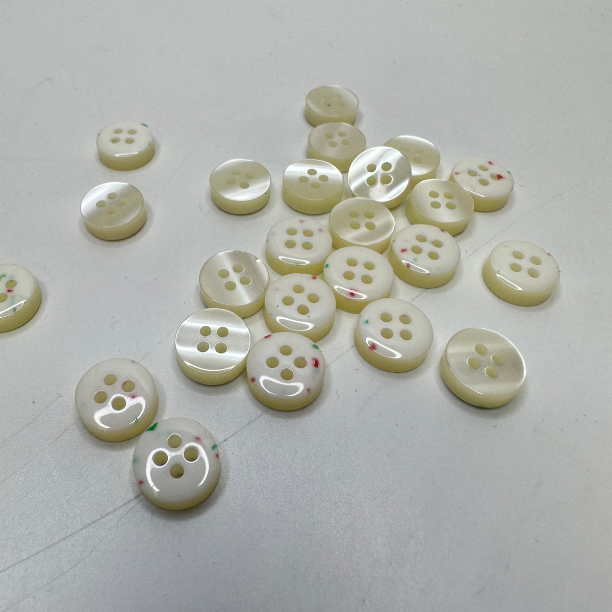 4 Hole Button - 10MM Plastic - Cream/Grn & Pink Speckles - 25 Pack - True Deadstock supplies Fabric by private - Sustainable Textile | FABCYCLE
